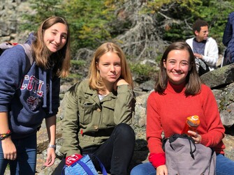 three female students posing together outside